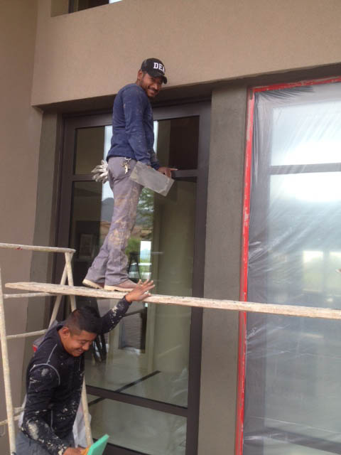 Installers work on the new entry door for this entry way remodel.