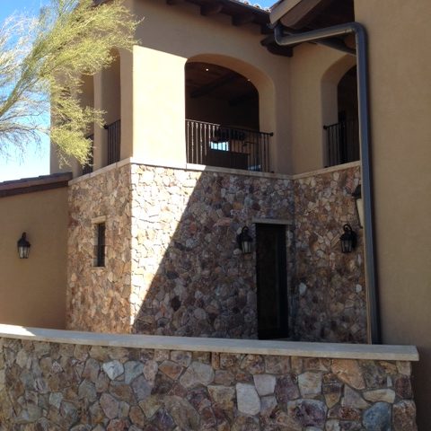 Splendid stonework accents the solid stucco trimmed by iron railings.