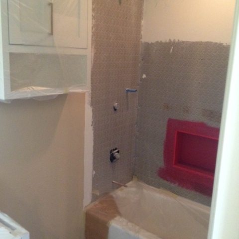 Cabinet installed and protected; old fixtures and walls removed.