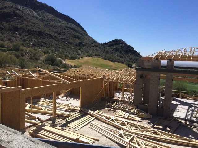 Trusses and framing materials lay on the ground waiting for the framers to build the frame.